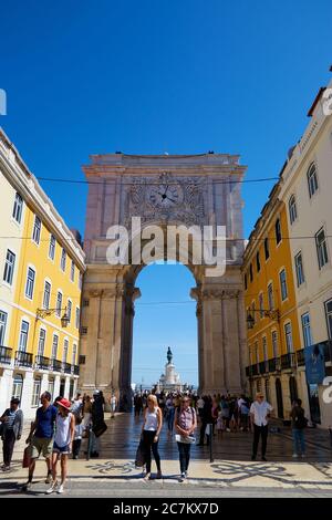 Vertikale Aufnahme des Pracala do Comércio aus den Hauptstraßen von Lissabon mit vielen Touristen, die herumlaufen Stockfoto