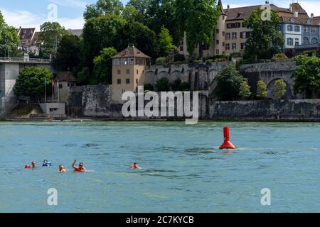 Basel, BL / Schweiz - 8. Juli 2020: Junge Männer schwimmen und schwimmen im Sommer gerne den Rhein hinunter Stockfoto