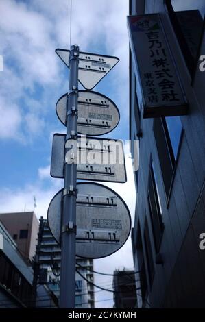 Low-Winkel-Aufnahme von Straßenschildern in verschiedenen Formen angebracht An einem wolkigen Tag zu einem Metallmast Stockfoto