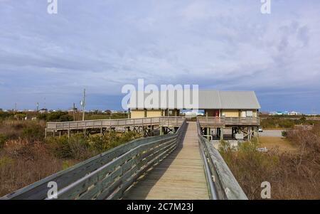 Grand Isle, Louisiana - Februar 2018: Ein Pier ermöglicht es den Menschen, über den Sand zu wandern und einen Blick auf den Golf von Mexiko im Grand Isle State Park zu genießen. Stockfoto