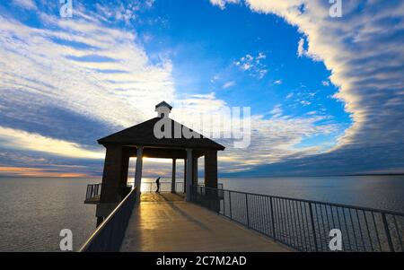 Fontainebleau State Park, Louisiana - Februar 2018: Die Silhouette eines Besuchers in einem Pavillon über dem Lake Pontchartrain im Fontainebleau State Park. Stockfoto