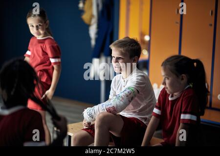 Team-Betreuung auf Sport Junge nach einem körperlichen Unfall. Stockfoto