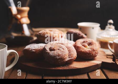 Snake Donuts mit Puderzucker und chemex Kaffee auf einem Holztisch Stockfoto