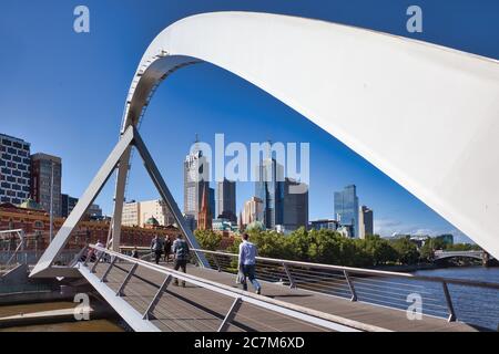 Melbourne Skyline vom Fluss Yarra mit der modernen Fußgängerbrücke über den Yarra River im Vordergrund, Melbourne, Victoria, Australien. Stockfoto