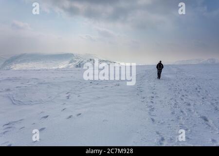 Eine Person, die über einen verschneiten Schnee ging, fiel in Richtung Mardale ill Bell im Lake District National Park, Cumbria Stockfoto