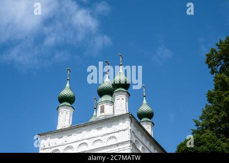 Grüne Kuppeln der orthodoxen Kirche mit goldenen Kreuzen auf einem Hintergrund des blauen Himmels an einem sonnigen Sommertag. Stockfoto