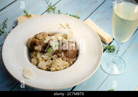 Risotto mit Steinpilz, Parmesan, Thymian und Weißwein auf Holzgrund Stockfoto