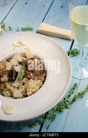 Risotto mit Steinpilz, Parmesan, Thymian und Weißwein auf Holzgrund Stockfoto