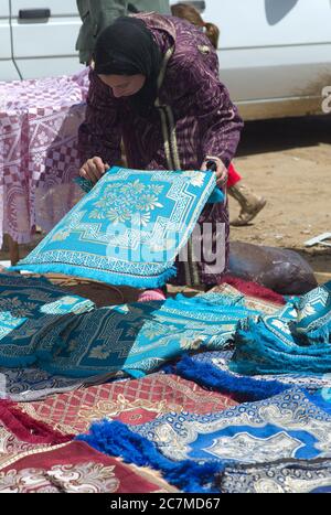 Arabische Frauen auf einem Markt (Souk) mit bunten Teppichen in einem Dorf in der Nähe von Fes in Marokko Stockfoto