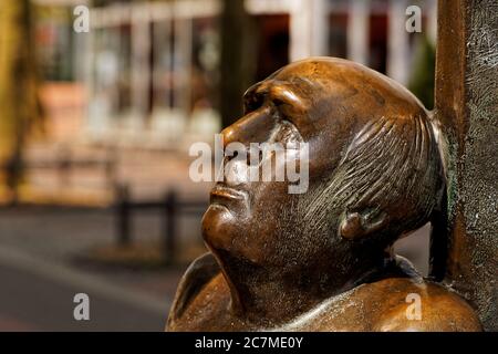 Selektive Fokusaufnahme einer holzgeschnitzten braunen Statue eines Kopf eines Mannes mit einem verschwommenen Hintergrund Stockfoto