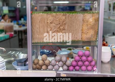 Mehrere Reisnudeln und farbige 1000 Jahre alte Eier in Vitrine in Nordthailand Stockfoto