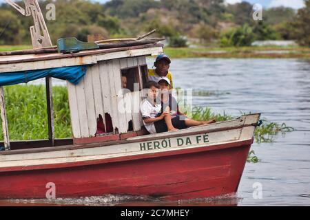 Drei Jungen auf einem kleinen Boot im Dorf Boca De Valeria am Amazonas, Amazonas Staat, Brasilien. Stockfoto