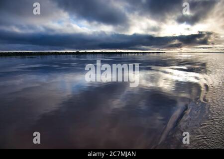 Blick über den Amazonas mit spiegelglatter Oberfläche, die genau den Himmel und die Wolken darüber reflektiert, in der Nähe von Manaus, Amazonas-Staat, Brasilien Stockfoto