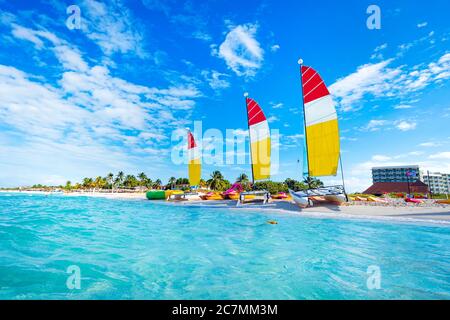 Segeln bunten Katamarane ist auf dem weißen Sand an der Küste vor dem Hintergrund der schönen tropischen Natur geparkt Stockfoto