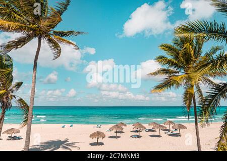 Varadero an einem sonnigen Tag. Wunderschöner Urlaub. Schöner Strand mit Liegen, Strohschirmen und Palmen. Luxus-Strand vor dem Hintergrund Stockfoto