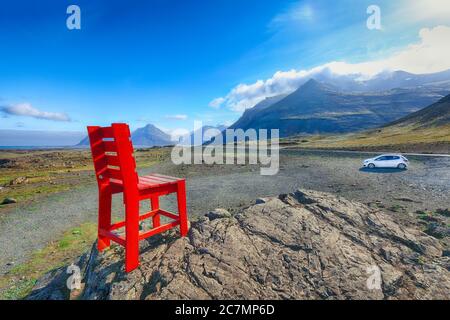 Herrlicher sonniger Tag und roter Stuhl zwischen Höfn und Egilsstadir in Island. Lage: Stokksnes Kap, zwischen Hofn und Egilsstadir, Island, Europa. Stockfoto