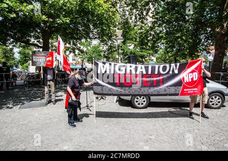 München, Bayern, Deutschland. Juli 2020. 'Migration tötet' auf Schildern der Neonazis NPD in München. Nach einer Pause, die zum Teil auf die Coronavirus-Krise und politische Verluste von Mitgliedern und Mitarbeitern wie Karl Richter zurückzuführen war, tauchten sechs von der neonazi NPD-Partei am Münchener Rotkreuzplatz mit bis zu 100 Gegendemonstranten gegen sie auf. Die Partei brachte während der Demonstration ihren Slogan "Migration Toetet" zurück und hat im August mehr versprochen. Unter anderem hatte die kleine Gruppe Verbindungen zu Mitgliedern der Terror Gruppe S. (Credit IMA Stockfoto