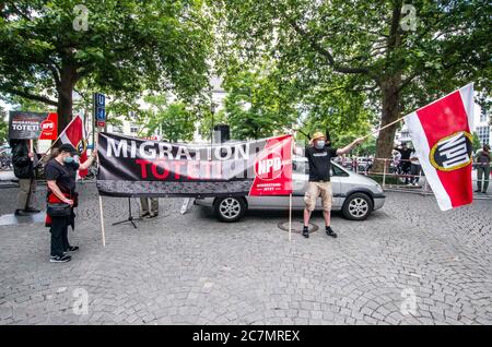 München, Bayern, Deutschland. Juli 2020. 'Migration tötet' auf Schildern der Neonazis NPD in München. Nach einer Pause, die zum Teil auf die Coronavirus-Krise und politische Verluste von Mitgliedern und Mitarbeitern wie Karl Richter zurückzuführen war, tauchten sechs von der neonazi NPD-Partei am Münchener Rotkreuzplatz mit bis zu 100 Gegendemonstranten gegen sie auf. Die Partei brachte während der Demonstration ihren Slogan "Migration Toetet" zurück und hat im August mehr versprochen. Unter anderem hatte die kleine Gruppe Verbindungen zu Mitgliedern der Terror Gruppe S. (Credit IMA Stockfoto
