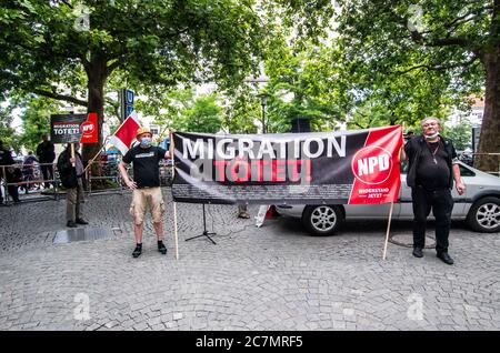 München, Bayern, Deutschland. Juli 2020. 'Migration tötet' auf Schildern der Neonazis NPD in München. Nach einer Pause, die zum Teil auf die Coronavirus-Krise und politische Verluste von Mitgliedern und Mitarbeitern wie Karl Richter zurückzuführen war, tauchten sechs von der neonazi NPD-Partei am Münchener Rotkreuzplatz mit bis zu 100 Gegendemonstranten gegen sie auf. Die Partei brachte während der Demonstration ihren Slogan "Migration Toetet" zurück und hat im August mehr versprochen. Unter anderem hatte die kleine Gruppe Verbindungen zu Mitgliedern der Terror Gruppe S. (Credit IMA Stockfoto