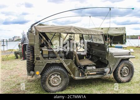 Mai 09 2014 Brisbane Australien Lebensgeschichte Nachstellung - WW2 Jeep mit Antennen gebunden und Schaufel zur Seite gesichert - Mann in Armee Uniform mit pa Stockfoto