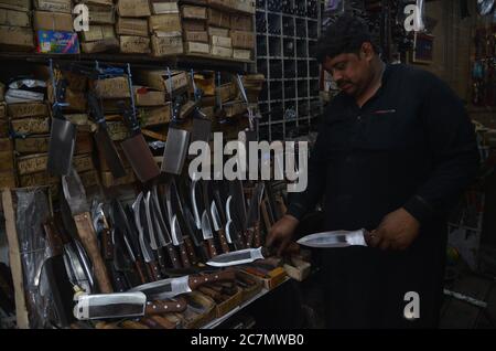 Pakistanische Schmiede schärfen Fleischspalter verschiedene Werkzeuge und Messer, um Tiere in ihrem Metallgeschäft vor dem muslimischen Fest von Eid al-Adha in Lahore, Pakistan, am 7. Juli 2020 zu opfern. Muslime auf der ganzen Welt feiern "Eid ul-Adha", auch bekannt als das Opferfest (Qurbani), um den islamischen Monat Zil Hijjah zu feiern. Schlachtung von Schafen, Ziegen, Kühen und Kamelen zum Gedenken an die Bereitschaft des Propheten Abraham, seinen Sohn Ismail auf Gottes Befehl zu opfern. (Foto von Rana Sajid Hussain/Pacific Press/Sipa USA) Stockfoto