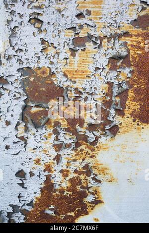 Grunge Hintergrund - Struktur der geschälten Farbe auf der Oberfläche. Unter ihm befindet sich rostiger Stoff. Stockfoto
