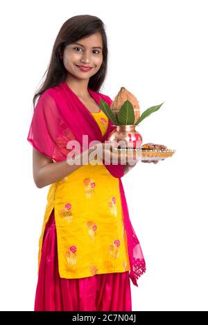 Indische Mädchen hält eine traditionelle Kupfer Kalash mit Pooja Thali, Indian Festival, Kupfer Kalash mit Kokosnuss und Mangoblatt mit Blumendekoration, e Stockfoto