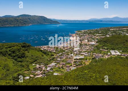 Faszinierende Aufnahme der gemütlichen kleinen Häuser umgeben von viel Grün Und Meer Stockfoto