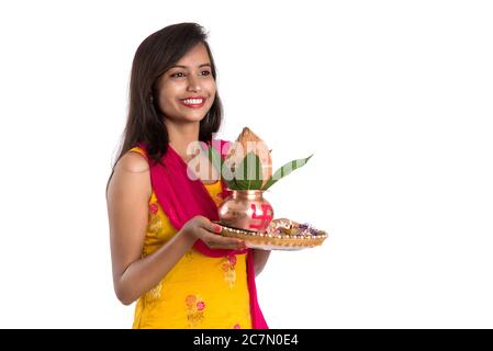 Indische Mädchen hält eine traditionelle Kupfer Kalash mit Pooja Thali, Indian Festival, Kupfer Kalash mit Kokosnuss und Mangoblatt mit Blumendekoration, e Stockfoto