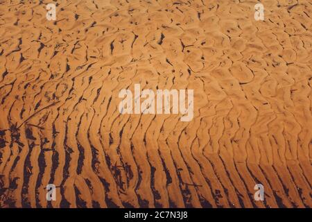 Nahaufnahme der Muster auf dem braunen Sand Stockfoto