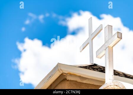 Ranchos de Taos Nahaufnahme der Kirche San Francisco de Asis Dachkreuz auf Turm mit Kreuz in New Mexico niedrigen Winkel Blick auf blauen Himmel Stockfoto