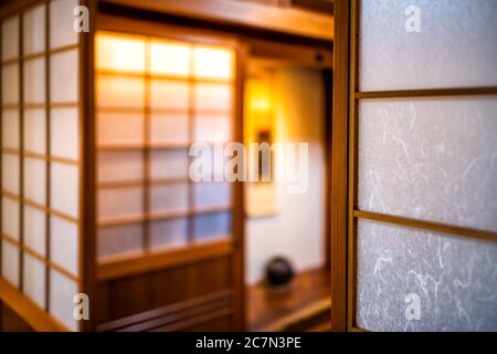 Traditionelles und modernes japanisches Haus Ryokan Hotelzimmer mit hölzernen Schiebepapier Shoji Türen und Nische in verschwommenem Hintergrund Stockfoto