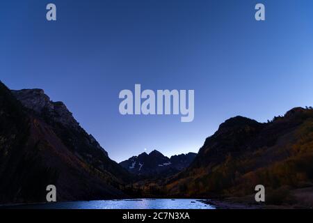 Maroon Bells See Weitwinkel Blick auf dunkle Nacht Abendhimmel in Aspen, Colorado mit felsigen Berggipfel im Oktober 2019 Herbst und Mond Reflexion in Stockfoto