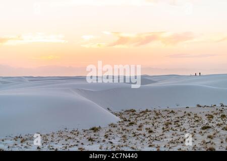 White Sands National Park Monument Hügel von Gipssanddünen und Pflanzen in New Mexico mit Orgel Berge Silhouette am Horizont in bunten roten Stockfoto