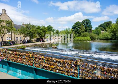 Auf der Brücke über den Fluss Wye in der Marktstadt von Derbyshire im Stadtteil Bakewell Derbyshire Peak wurden Vorhängeschlösser in Erinnerung an die Angehörigen hinterlassen Stockfoto