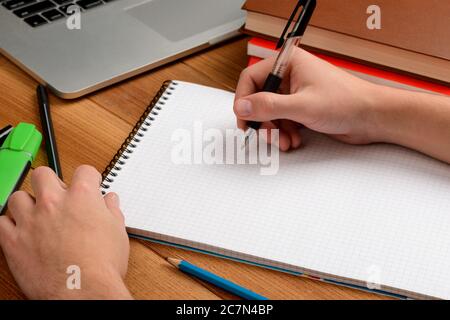 Kursteilnehmer, der mit einem Stift Notizen in einem Notizblock macht Stockfoto