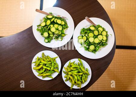 Holztisch Tablett flach oben Blick nach unten und grünen Salat mit japanischen Gurken, edamame mizuna Greens zu Hause Haus innen im Ryokan Hotel oder Stockfoto