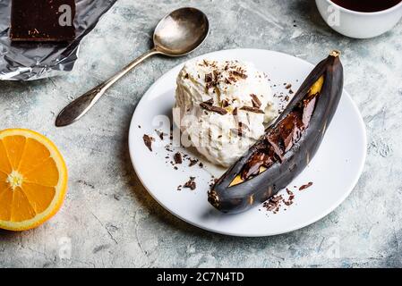 Gegrillte Banane mit dunkler Schokolade und Vanilleeis. Stockfoto