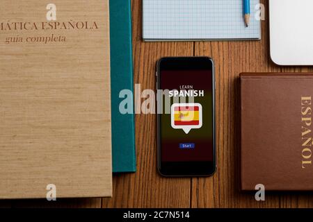 Spanisch lernen App und Lehrbücher auf Holztisch Stockfoto