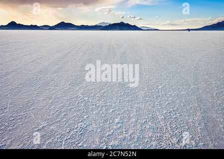 Bonneville Salt Flats Weitwinkelansicht der Textur im Vordergrund und Sturmwolken in der Nähe von Salt Lake City, Utah und Bergblick während des Sonnenuntergangs mit niemand Stockfoto