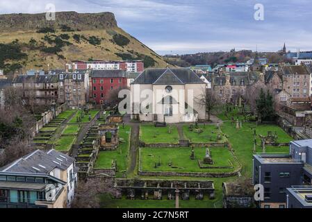 Kirk of the Canongate und Friedhof in Edinburgh, der Hauptstadt von Schottland, Teil von Großbritannien, Blick mit Holyrood Park im Hintergrund Stockfoto