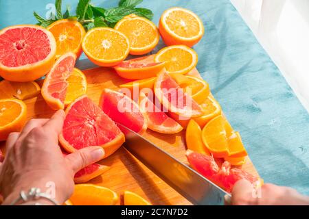 Frisch geschnittene Grapefruit und Orangenscheiben mit blauem Holzhintergrund. Stockfoto