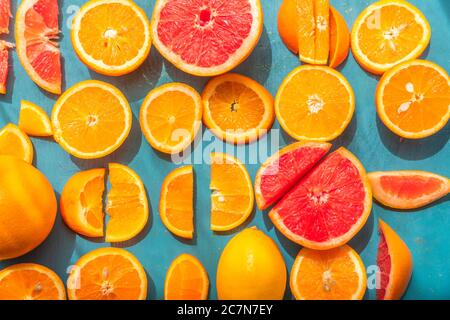 Frisch geschnittene Grapefruit und Orangenscheiben mit blauem Holzhintergrund. Stockfoto