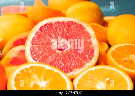 Frisch geschnittene Grapefruit und Orangenscheiben mit blauem Holzhintergrund. Stockfoto