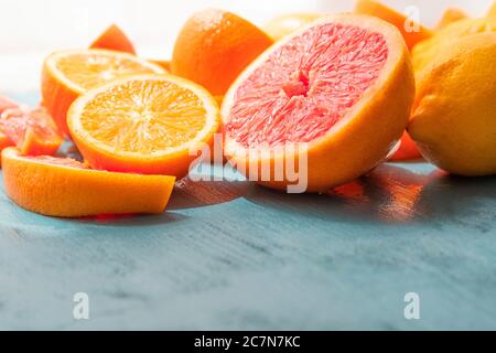 Frisch geschnittene Grapefruit und Orangenscheiben mit blauem Holzhintergrund. Stockfoto