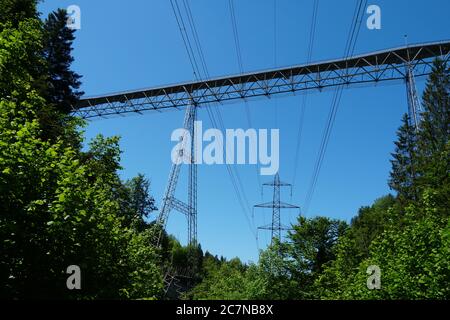 Brücke auf St. Galler Brücke Wanderweg, Fachwerkbrücke Haggen-Stein, unterstützt von Metallmasten eingebettet auf schräg dicht von Vegetation bedeckt. Stockfoto