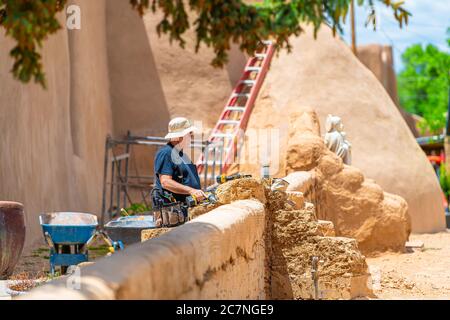 Ranchos de Taos, USA - 19. Juni 2019: St. Francic Plaza und San Francisco de Asis Kirche mit Mann während der Bauarbeiten in New Mexico im Norden renoviert Stockfoto