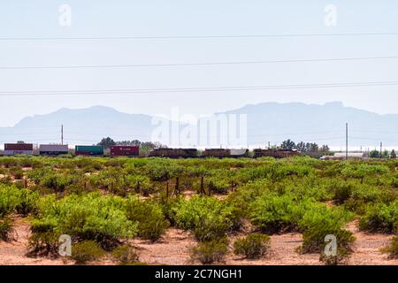 Tularosa, USA - 8. Juni 2019: New Mexico Sacramento Mountains Silhouette in Otero County mit Güterzug auf Schienen und Schild für Kline Versand Stockfoto