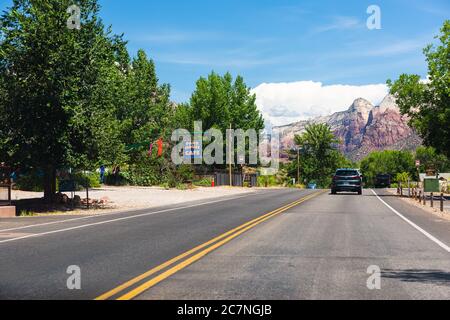 Springdale, USA - 5. August 2019: Zion National Park Road in Utah und Autos im Straßenverkehr Sicht Fahren in der Stadt mit Restaurant Shop Stores s Stockfoto