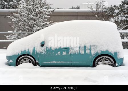 Ein geparkter Mininvan ist während eines seltenen Schneesturms an der Westküste in Victoria, British Columbia, Kanada, auf Vancouver Island mit Schnee bedeckt. Stockfoto